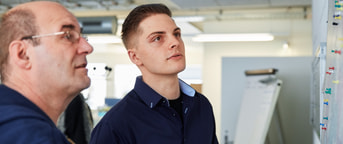 Männer studieren Anschlag an der Wand Männer studieren Anschlag an der Wand